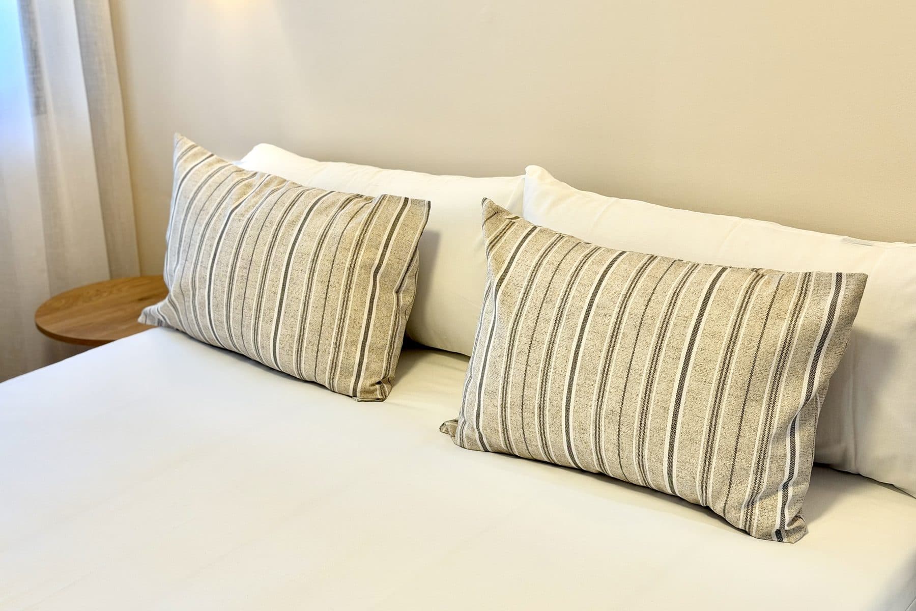 Detalle de cojines de lino a rayas sobre la cama