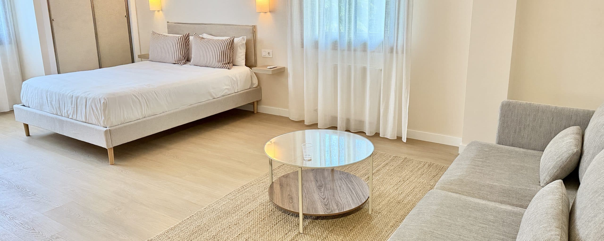 Estudio con zona de estar separada del dormitorio por un biombo de listones