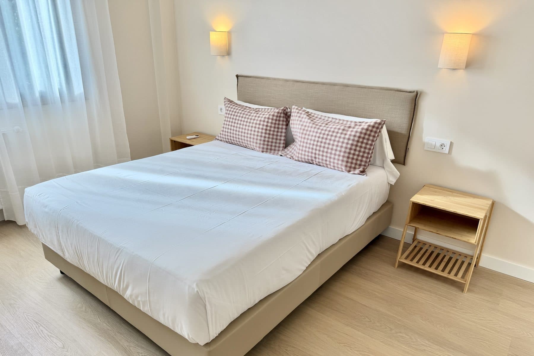Cama vestida de una habitación doble con cabecero tapizado