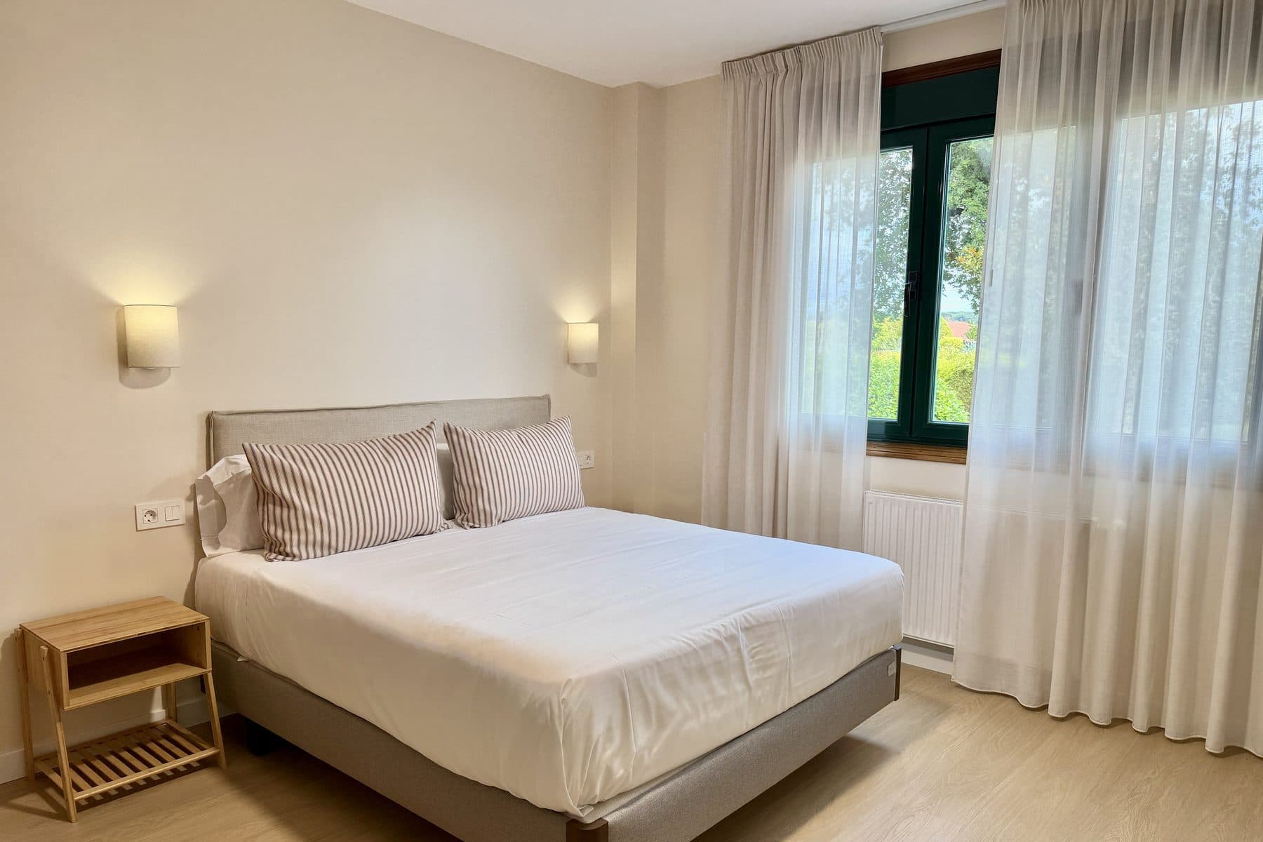 Habitación doble con ventana de marco verde y vistas al jardín